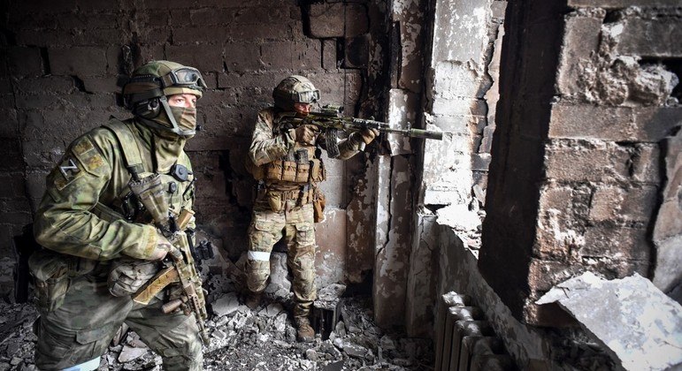 Soldados russos patrulham prédio em Mariupol, cidade destruída pela guerra