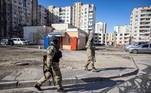 Soldados ucranianos caminham em área residencial de Kiev que sofreu com os ataques russos