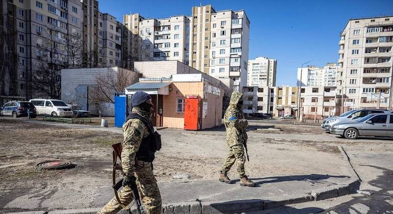 Soldados ucranianos caminham em área residencial de Kiev, capital do país