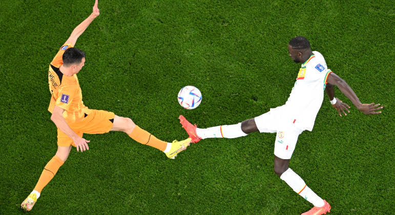 Steven Berghuis (esq), da Holanda, e Cheikhou Kouyate, de Senegal, disputam a bola na estreia das duas seleções na Copa