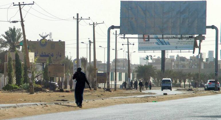 Homem caminha pelas ruas de Cartum, capital do Sudão, nesta segunda-feira (17)