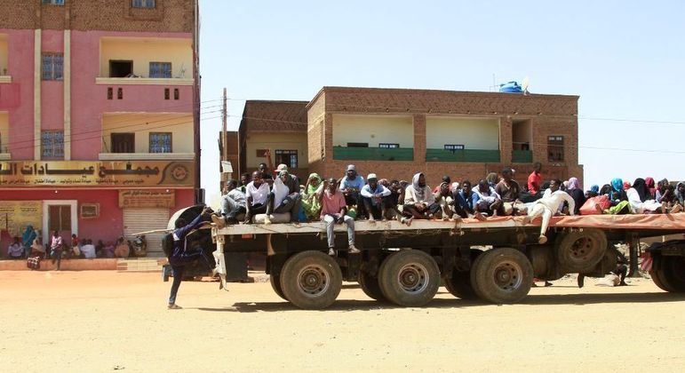 Pessoas usam caminhão para fugir dos conflitos em Cartum, capital do Sudão