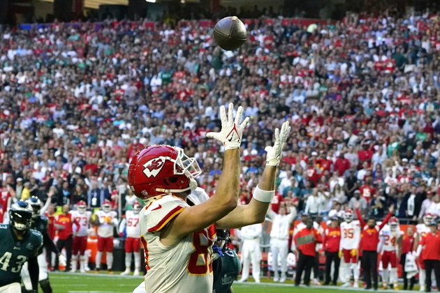 O tight end do Kansas City Chiefs, Travis Kelce, pega a bola e corre para marcar um touchdown 