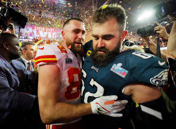 Travis Kelce, do Kansas City Chiefs, com seu irmão, Jason Kelce, do Philadelphia Eagles, enquanto o Chiefs comemora após vencer o Super Bowl 57