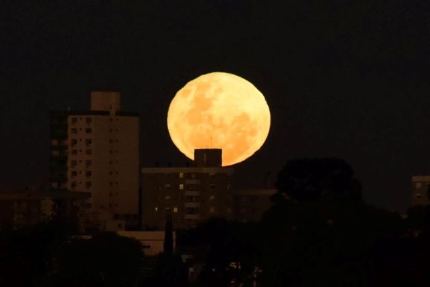 A Superlua de Morango apareceu na noite desta terça-feira (14) e madrugada de quarta (15) no céu do Brasil e de muitos países mundo afora. 14% maior e 30% mais brilhante, o satélite natural da Terra encantou as pessoas que pararam para ver o fenômeno. Na foto, você vê a lua na cidade de Passo Fundo, no Rio Grande do Sul