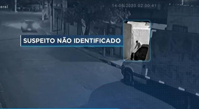 Homem aparece nas imagens se abaixando e manuseando algo no chão
