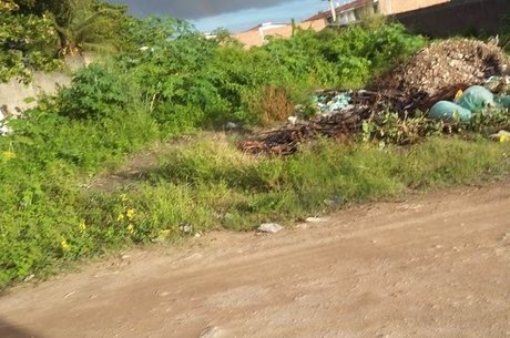 No bairro de Tabuleiro do Pinto, as casas não têm esgoto tratado, a rua não tem asfalto e há muito lixo espalhado pelo mato