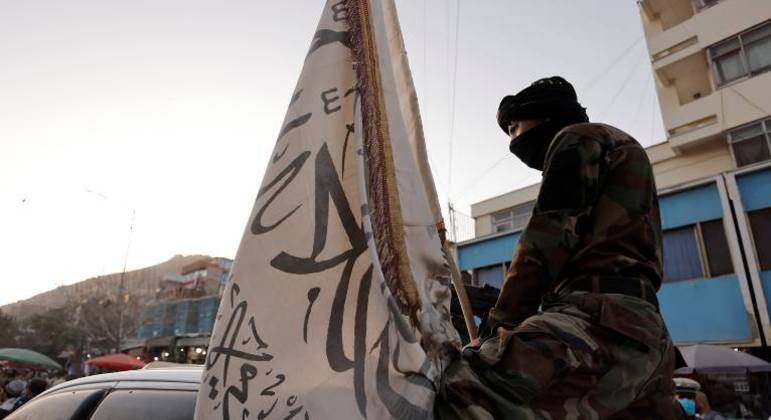 Soldado do Talibã segura uma bandeira do grupo extremista 