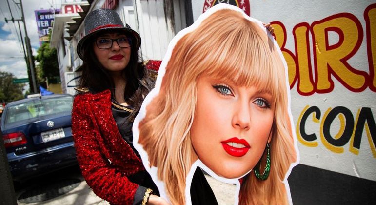 Fã de Taylor com pôster da cantora antes do show na Cidade do México nesta quinta (23)