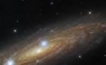 Já esta foto mostra UGC 11537, outra galáxia descoberta pelo Hubble, localizada a cerca de 230 milhões de anos-luz de distância. As duas estrelas do primeiro plano estão inseridas dentro da Via Láctea