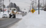 Também nesta segunda (26), trator retira a neve acumulada numa avenida na cidade de West Seneca, no estado de Nova York