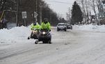 Em Buffalo, nesta segunda (26), homens usam veículos específicos para neve para se locomover pela cidade