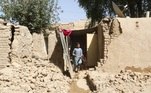 Garoto caminha em meio aos escombros após o terremoto que atingiu o Paquistão