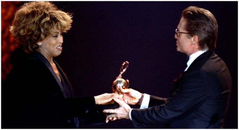 O ator Michael Douglas entrega um prêmio World Music para Tina Turner durante uma cerimônia em Monte Carlo, Mônaco