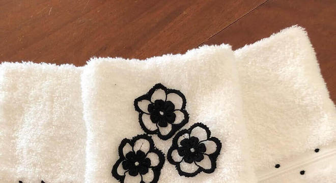 toalha de banho bordada com flores pretas e detalhe em renda 