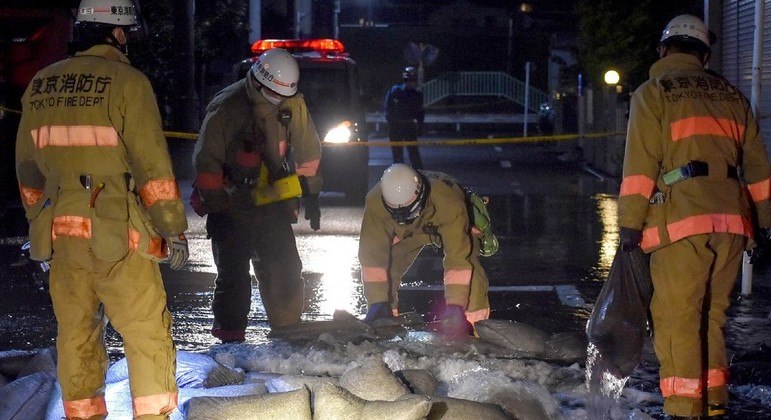 Membros do Corpo de Bombeiros de Tóquio tentam consertar um cano d´água após o terremoto
