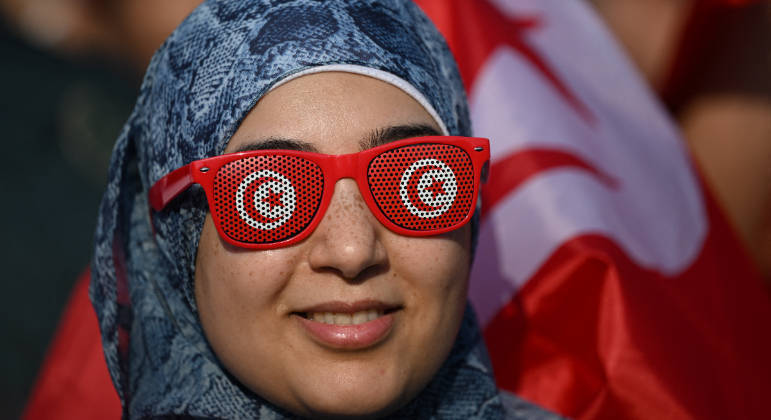 Torcedora da Tunísia usa óculos estiloso para ver a partida contra a Dinamarca na Copa
