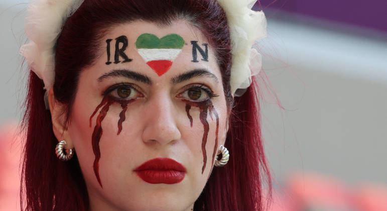 Estádio também é lugar para protestar. Torcedora iraniana pintou lágrimas de sangue no rosto em recado à convulsão social que acontece no Irã