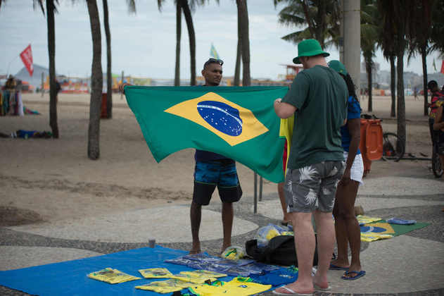 Torcedores compram bandeiras e camisas para pintar as areias de Copacabana com as cores do Brasil. 