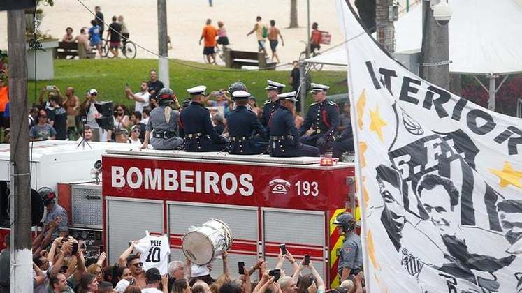 Torcedores homageavam Pelé em bandeiras e camisas em volta do carro dos bombeiros.