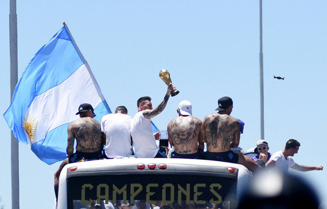 São eles! A seleção argentina acenou para os torcedores, e o troféu é o grande destaque do desfile a céu aberto