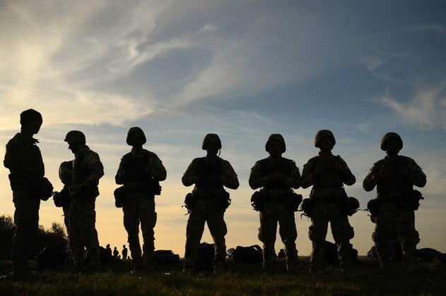 Com o rosto sujo de lama, recrutas ucranianos atravessam uma planície portando fuzis. Mas eles não estão na Ucrânia, e sim em terras usadas pelo Exército britânico na Inglaterra, para onde viajaram a fim de desenvolver habilidades no campo de batalha