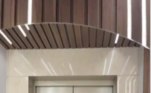 Assim como o lavabo, a entrada do apartamento também foi feita de madeira com luzes de led. Um espelho redondo foi colocado em frente ao elevadorVeja também: Arquitetura diferentona: você teria coragem de subir essas escadas?