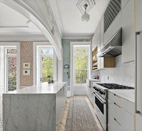 A cozinha em conceito aberto conta com bancadas de mármore Carrara e já tem os eletrodomésticos luxuosos todos instalados