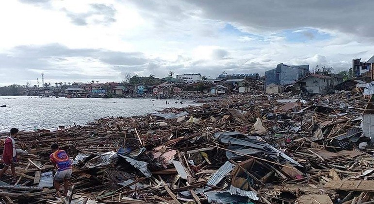 Moradores tentam resgatar pertences na província de Bohol após o tufão Rai atingir as Filipinas