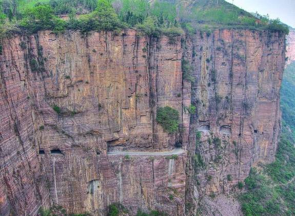 Túnel Guoliang (China) - Fica nas montanhas Taihang, na província de Henan, na China. Começou a ser construído em 1972 por treze aldeões liderados por Shen Mingxin.  Para jogar entulhos da escavação, eles abriram buracos que parecem 