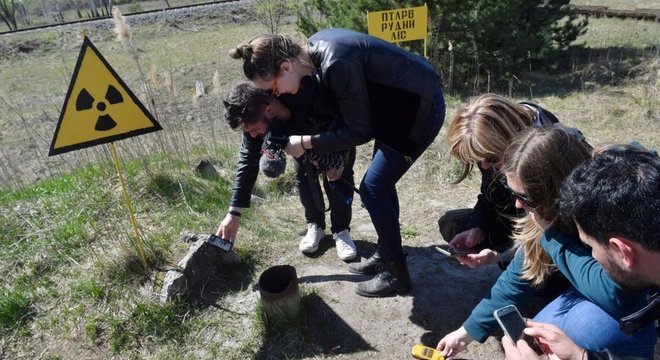 Nos arredores da usina atômica onde aconteceu o trágico acidente nuclear em Chernobyl, turistas costumam medir a radiação do loca