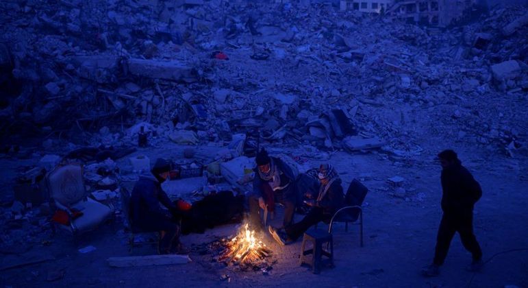 Sobreviventes do terremoto acendem fogueira para enfrentar o frio que faz no país