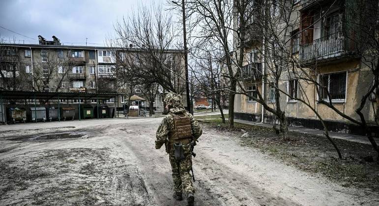 Soldado do Exército ucraniano caminha na cidade de Schastia, perto da cidade de Lugansk