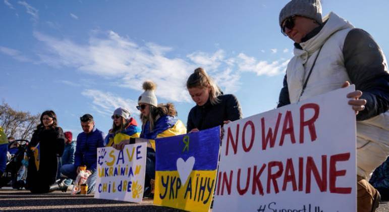 Manifestantes ajoelham-se durante manifestação contra a invasão da Rússia na Ucrânia, em Washington