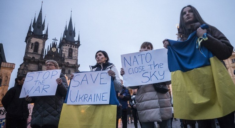 Manifestantes seguram cartazes durante manifestação em apoio à Ucrânia, em Praga