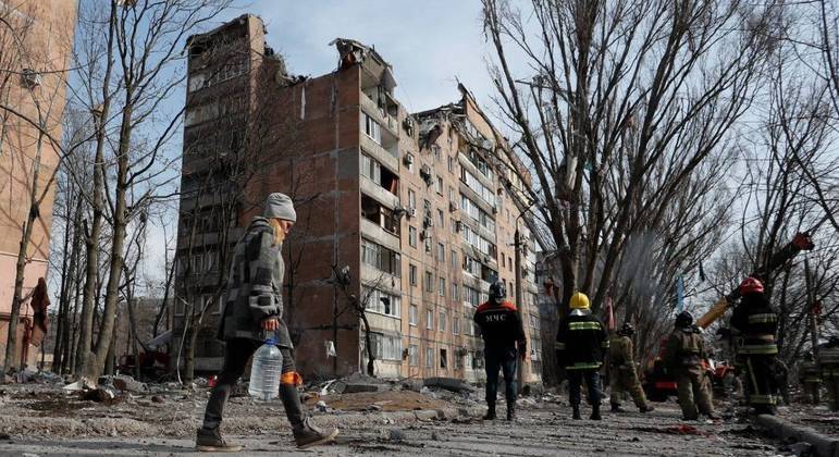 Bombeiros trabalham após um prédio ser bombardeado na região de Donetsk