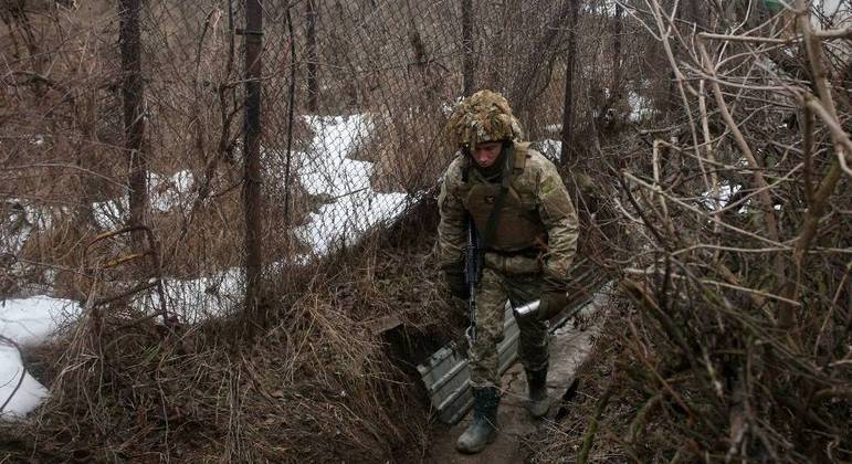 Soldado ucraniano percorre trincheira na fronteira com a Rússia em meio a tensões
