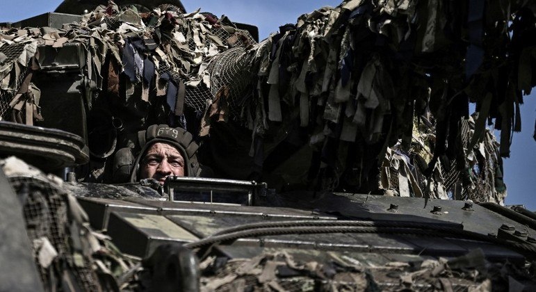 Soldado ucraniano dirige tanque de guerra em direção à linha de frente na região de Donbas