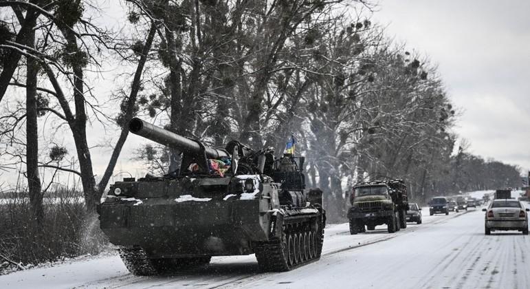 Um tanque ucraniano passa por uma estrada principal em meio à invasão russa 
