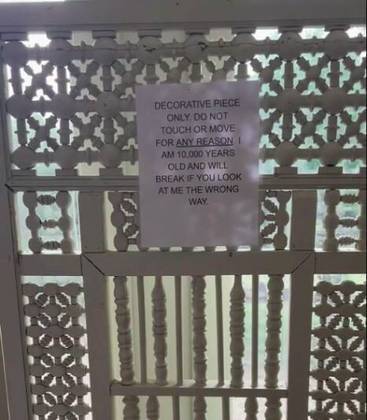 Um dos avisos mais inusitados é o que está colado em uma porta decorativa. O aviso diz 