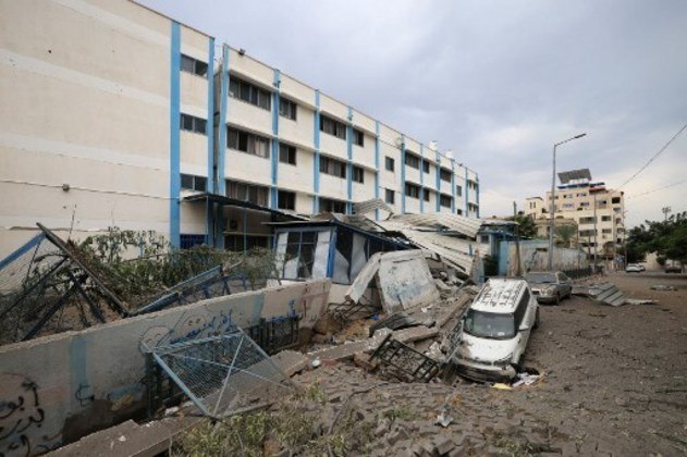 Uma foto tirada em 9 de outubro mostra os danos do lado de fora de uma escola administrada pela Agência das Nações Unidas de Assistência e Obras aos Refugiados da Palestina (UNRWA).