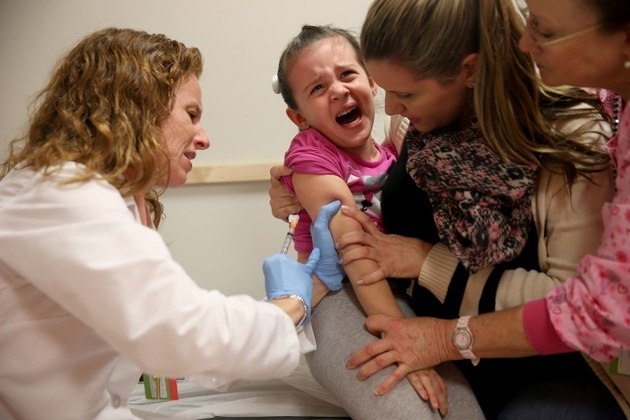 criança recebe vacina contra a gripe