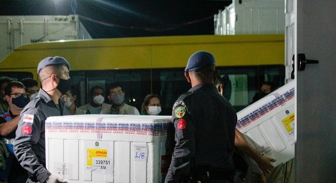 Soldados da PM descarregam caixas com doses da vacina AstraZeneca