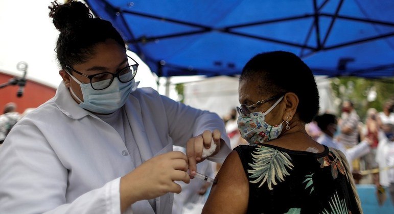 Uma senhora sendo vacinada em Duque de Caxias, no Rio de Janeiro