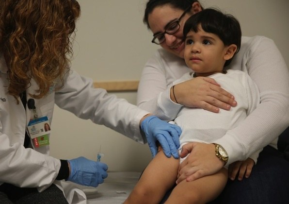 menino recebe vacina contra a gripe