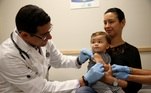 criança recebendo vacina no colo da mãe