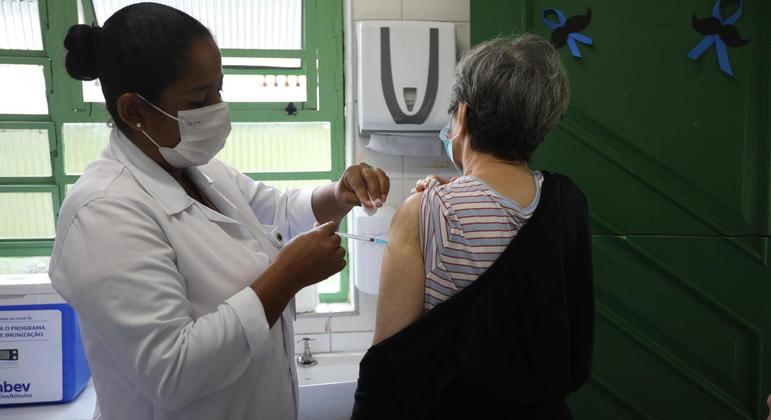 Mulher recebe vacina contra a Covid-19 em uma UBS da zona sul de São Paulo