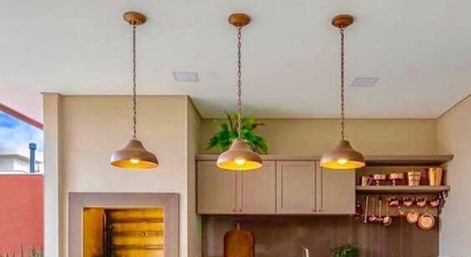 Varanda com churrasqueira e balcão com cadeiras combinando