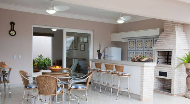 Varanda com churrasqueira e banquetas combinando