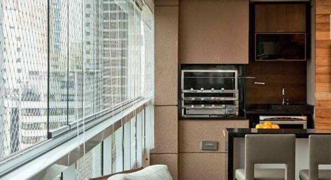 Varanda com churrasqueira e cortina de vidro